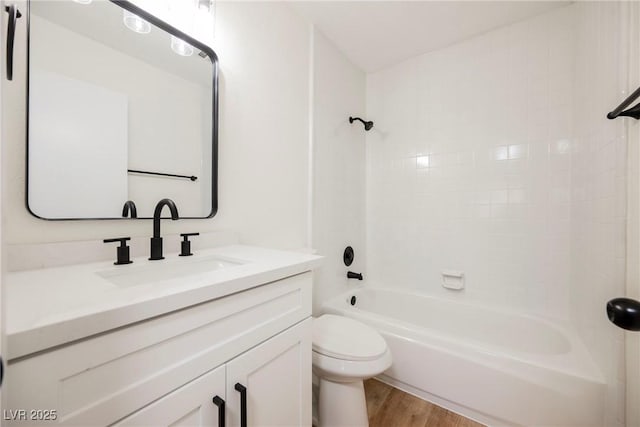 full bathroom featuring toilet, vanity, wood-type flooring, and bathing tub / shower combination