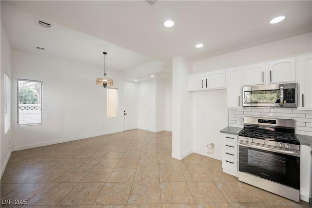 kitchen with white cabinets, appliances with stainless steel finishes, light tile patterned floors, and pendant lighting