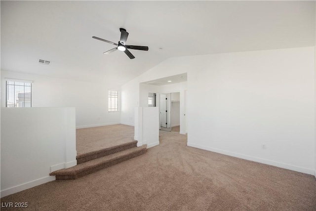 unfurnished room featuring a wealth of natural light, light colored carpet, lofted ceiling, and ceiling fan