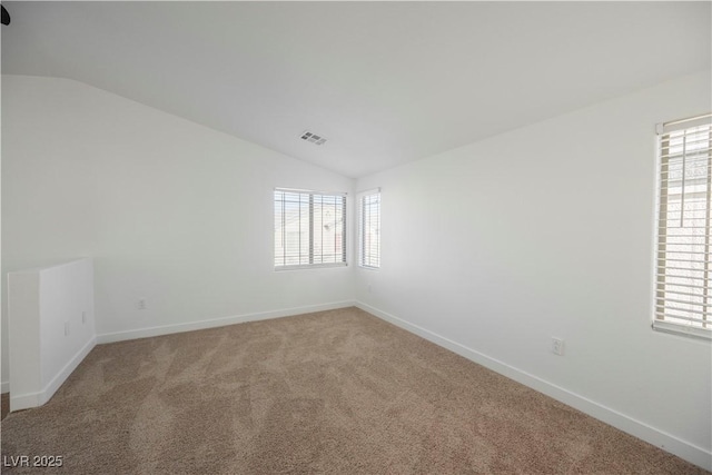 carpeted empty room with lofted ceiling