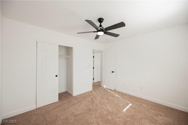 unfurnished bedroom featuring ceiling fan, a closet, and light carpet