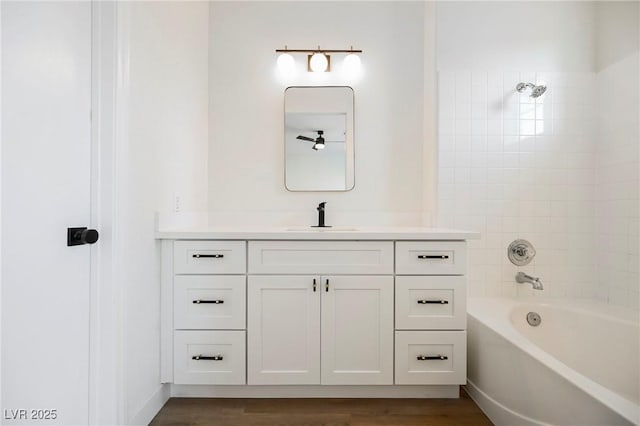 bathroom featuring tiled shower / bath, wood-type flooring, and vanity