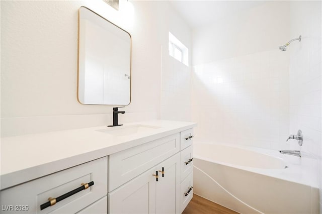 bathroom with hardwood / wood-style flooring, bathtub / shower combination, and vanity