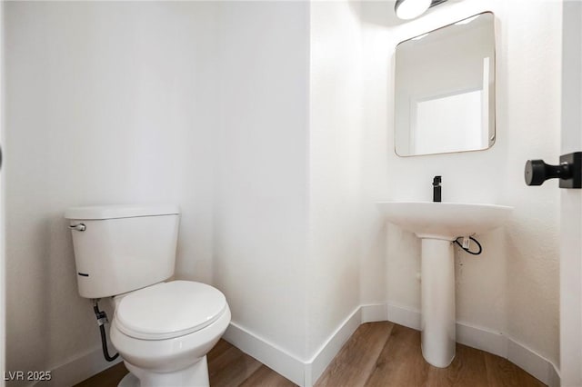 bathroom with toilet and hardwood / wood-style floors