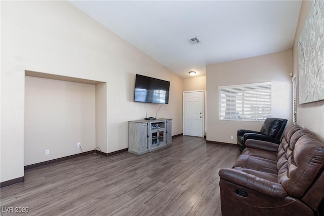 living room featuring lofted ceiling and hardwood / wood-style flooring