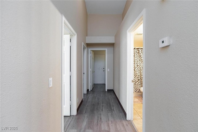 corridor with hardwood / wood-style flooring