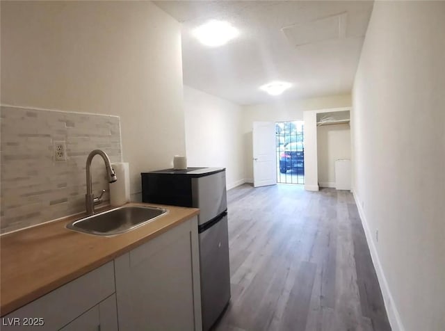 kitchen featuring sink, stainless steel fridge, decorative backsplash, and dark hardwood / wood-style floors