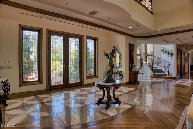 foyer entrance featuring french doors, light parquet flooring, and crown molding