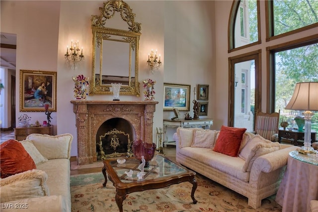 living area with a towering ceiling and a premium fireplace