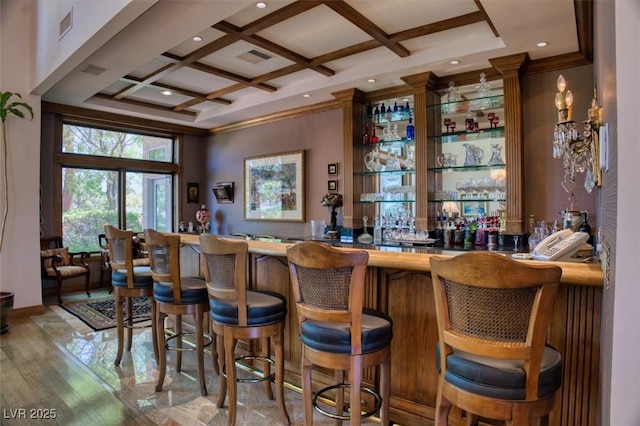 bar featuring beamed ceiling, ornamental molding, light hardwood / wood-style floors, and coffered ceiling