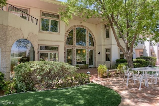 rear view of house with a patio and stucco siding