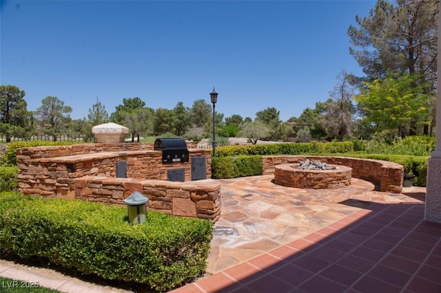 view of patio featuring an outdoor kitchen, a fire pit, and grilling area