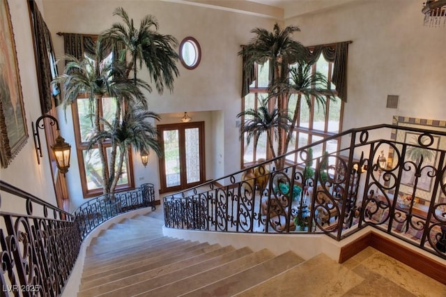 foyer entrance with french doors, visible vents, and a high ceiling