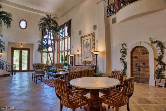 dining area featuring visible vents, arched walkways, baseboards, stairs, and french doors