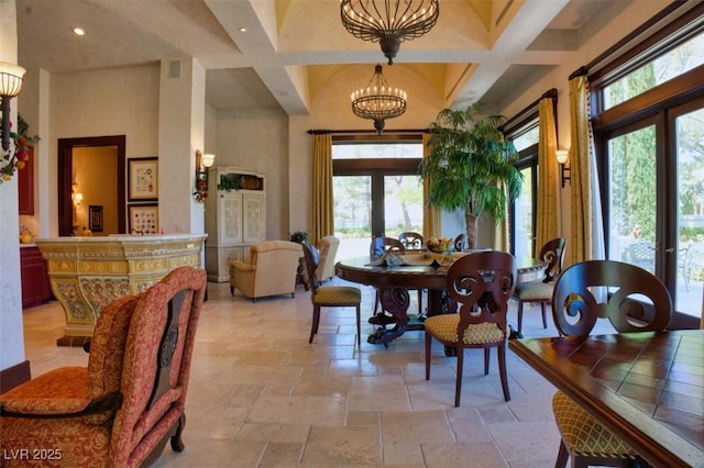 dining space with a high ceiling, an inviting chandelier, french doors, and plenty of natural light