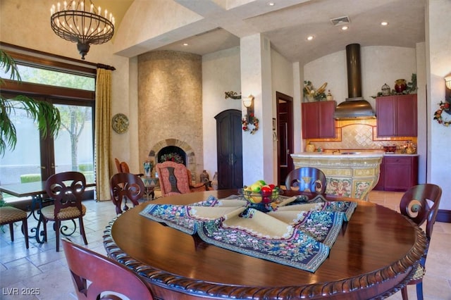 dining room with a chandelier, high vaulted ceiling, recessed lighting, stone tile floors, and visible vents