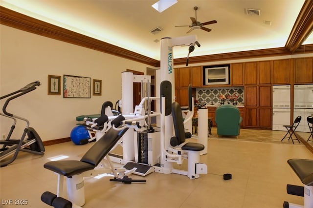 exercise room with baseboards, visible vents, a ceiling fan, and ornamental molding