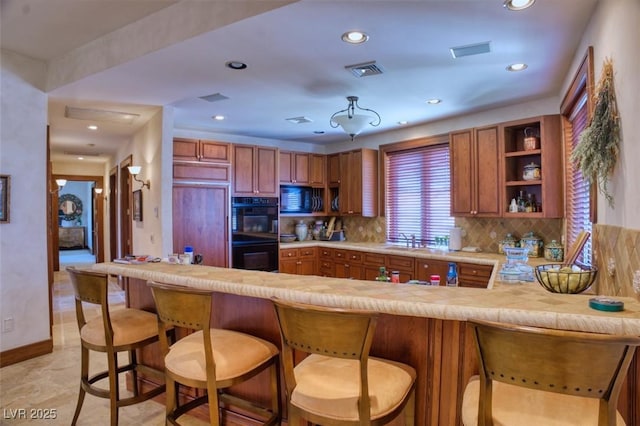 kitchen featuring visible vents, light countertops, black appliances, open shelves, and backsplash