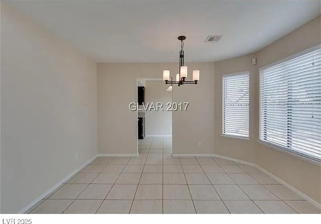 unfurnished dining area with a chandelier and light tile patterned floors