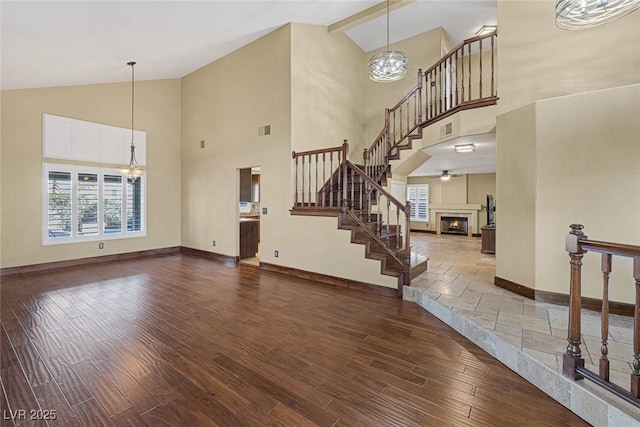 living room featuring high vaulted ceiling, an inviting chandelier, and hardwood / wood-style floors