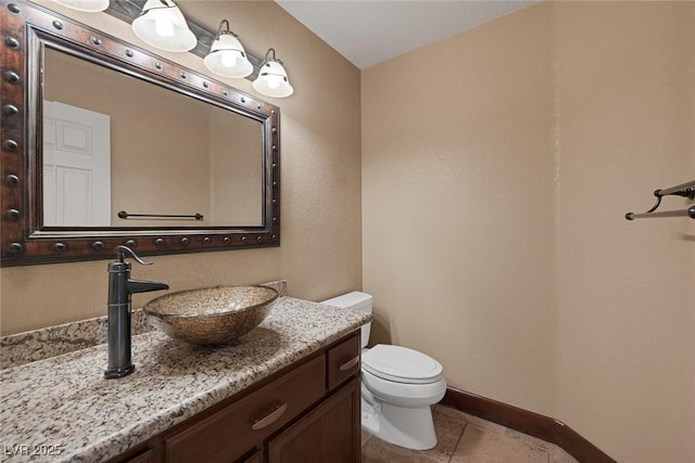 bathroom featuring toilet, vanity, and tile patterned flooring