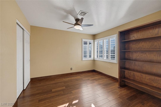 unfurnished bedroom with ceiling fan, dark hardwood / wood-style flooring, a closet, and a textured ceiling