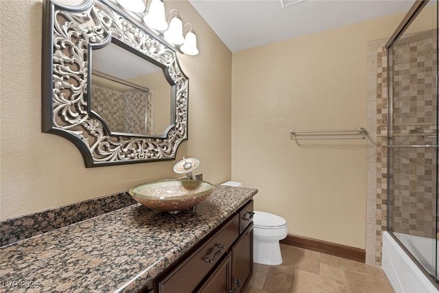 full bathroom with toilet, bath / shower combo with glass door, and vanity