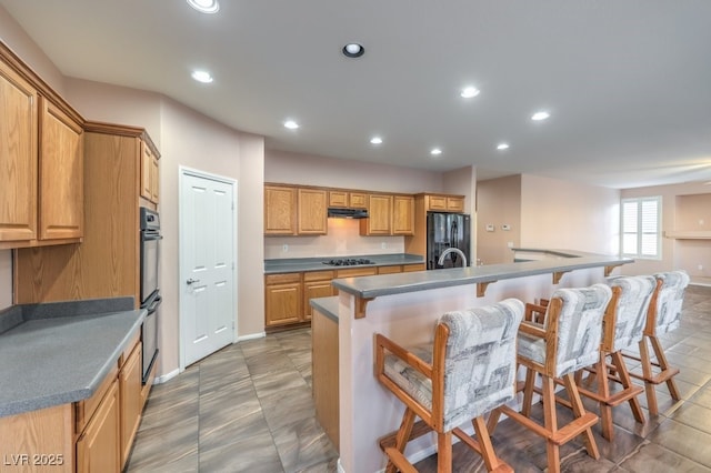 kitchen with black appliances and a center island with sink