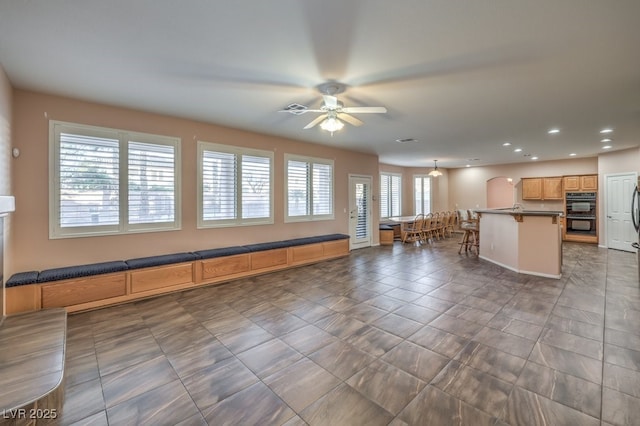 unfurnished living room with ceiling fan