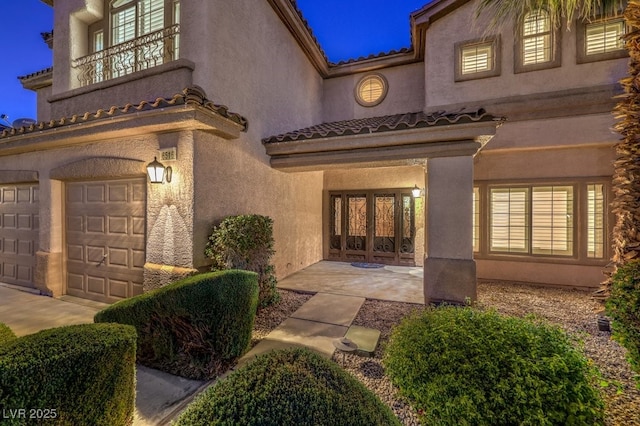 entrance to property featuring a balcony and a garage