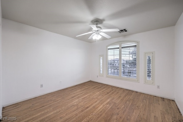 empty room with ceiling fan and hardwood / wood-style floors