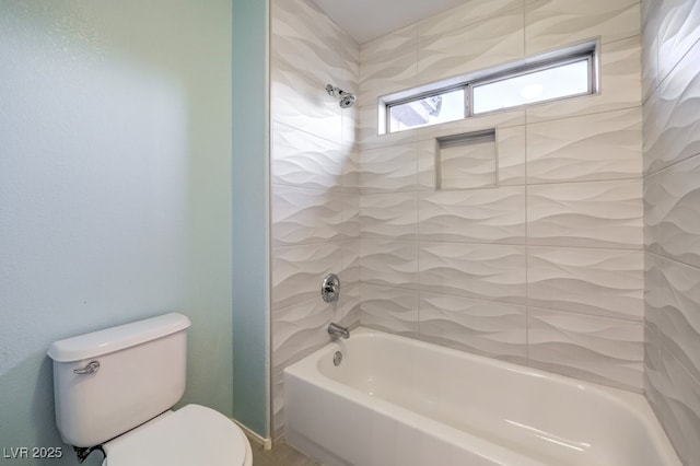 bathroom featuring tiled shower / bath combo and toilet