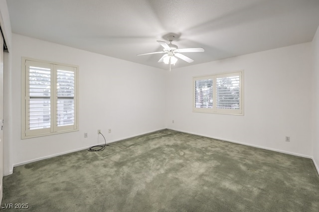 empty room with dark colored carpet and ceiling fan