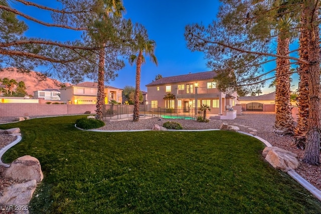 yard at dusk featuring a balcony and a garage