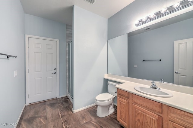 bathroom with toilet, an enclosed shower, and vanity