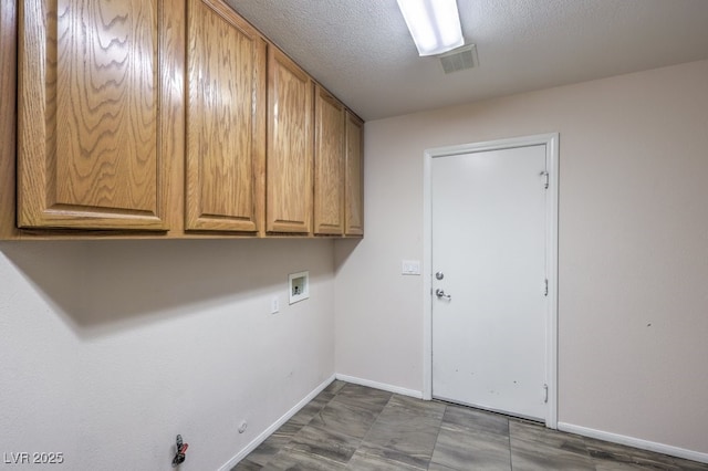 laundry area with a textured ceiling, cabinets, gas dryer hookup, and washer hookup