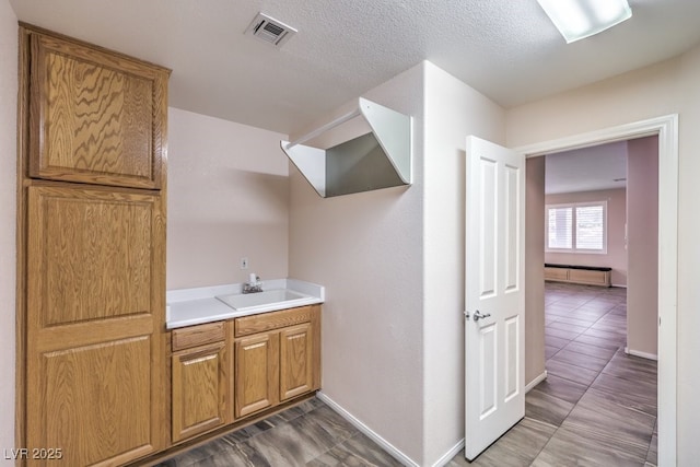 bathroom featuring a textured ceiling and sink