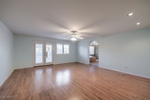 empty room with ceiling fan, french doors, and hardwood / wood-style floors