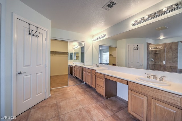 bathroom featuring a textured ceiling, tile patterned flooring, and vanity