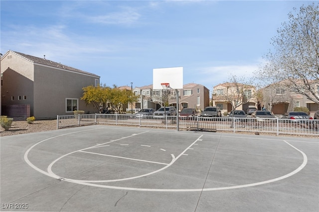 view of sport court featuring community basketball court, fence, and a residential view