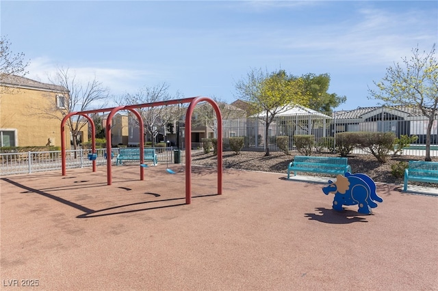 communal playground featuring a residential view and fence