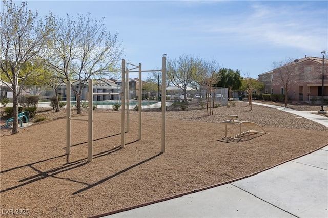 view of play area featuring a residential view, fence, and a community pool