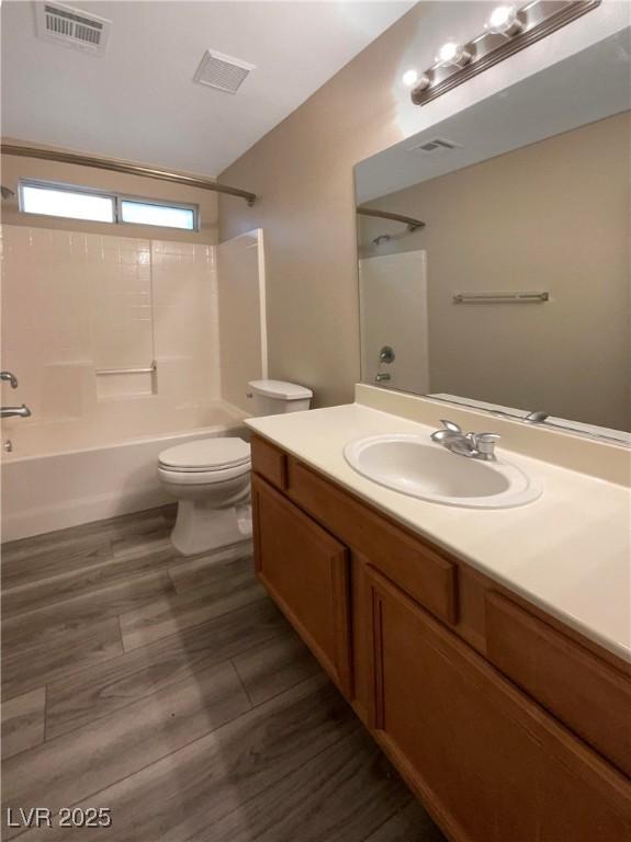 full bathroom featuring toilet, wood-type flooring, vanity, and shower / bath combination