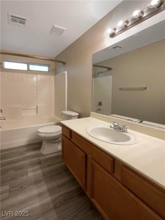 full bathroom featuring toilet, vanity, hardwood / wood-style floors, and bathing tub / shower combination