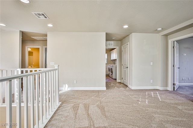 carpeted spare room featuring separate washer and dryer