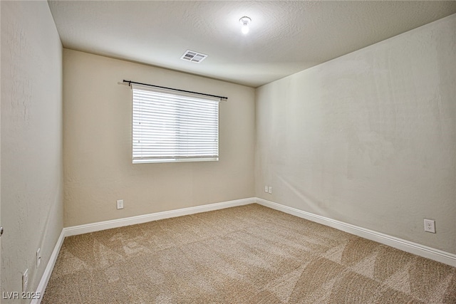 carpeted spare room with a textured ceiling