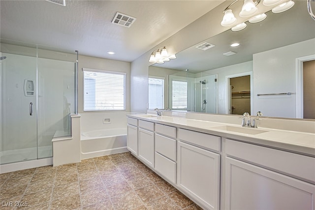 bathroom with independent shower and bath, a textured ceiling, and vanity