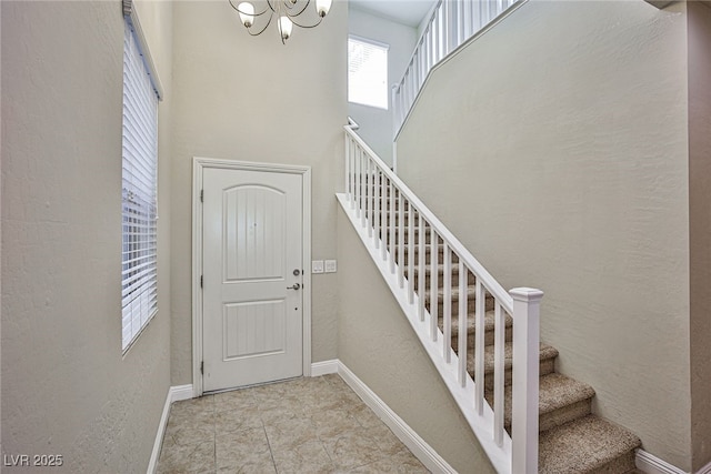 stairs featuring a high ceiling and a chandelier