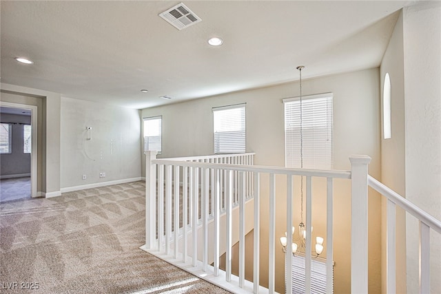 corridor featuring light colored carpet