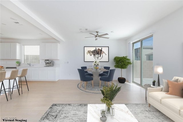 living room featuring sink, light hardwood / wood-style floors, ceiling fan, and a wealth of natural light